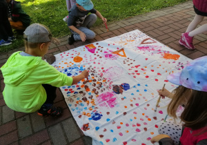 Dzieci malują kropki w ogrodzie